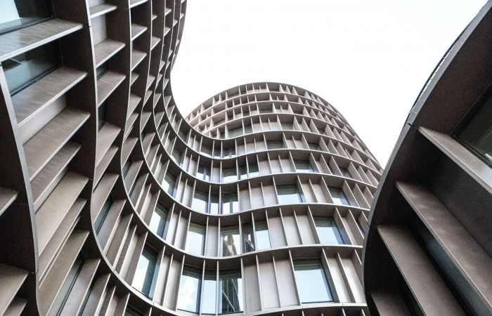 Nahaufnahme eines Ausschnitts eines modernen Bürogebäude mit geschwungener Fassade und vielen Fenstern