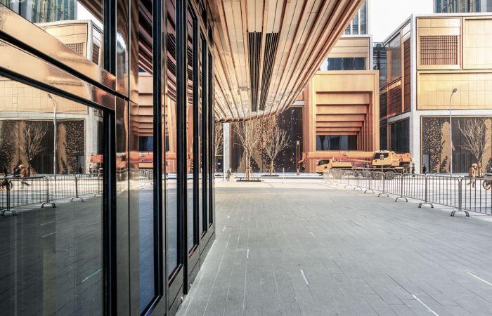 Front eines modernen Bürogebäudes mit Überdachung aus geschwungenem Holz