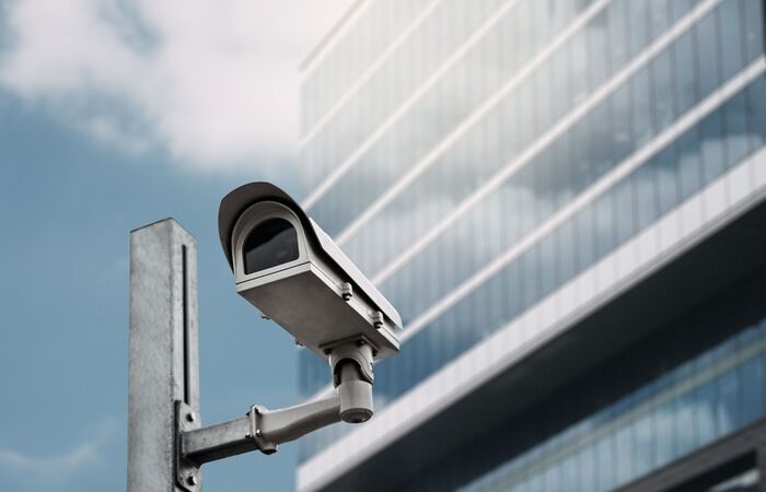 Nahaufnahme einer Überwachungskamera vor einem modernen Bürogebäude