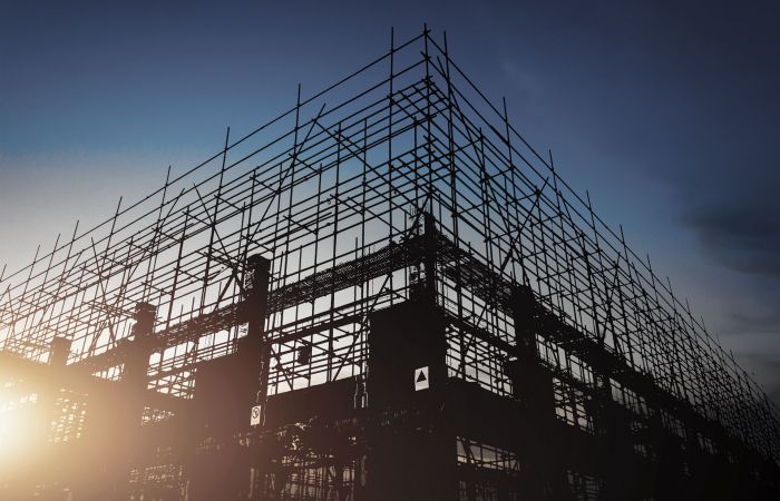 Baustelle bei Abendstimmung, bei der man die Armiereisen in den Himmel ragen sieht