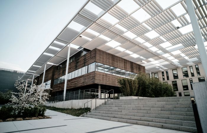 Gebäude in moderner Architektur mit Holzfassade und einem futuristischen Überdach