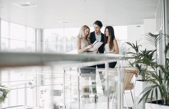 junge Geschäftsleute besprechen etwas miteinander in moderner, heller Umgebung