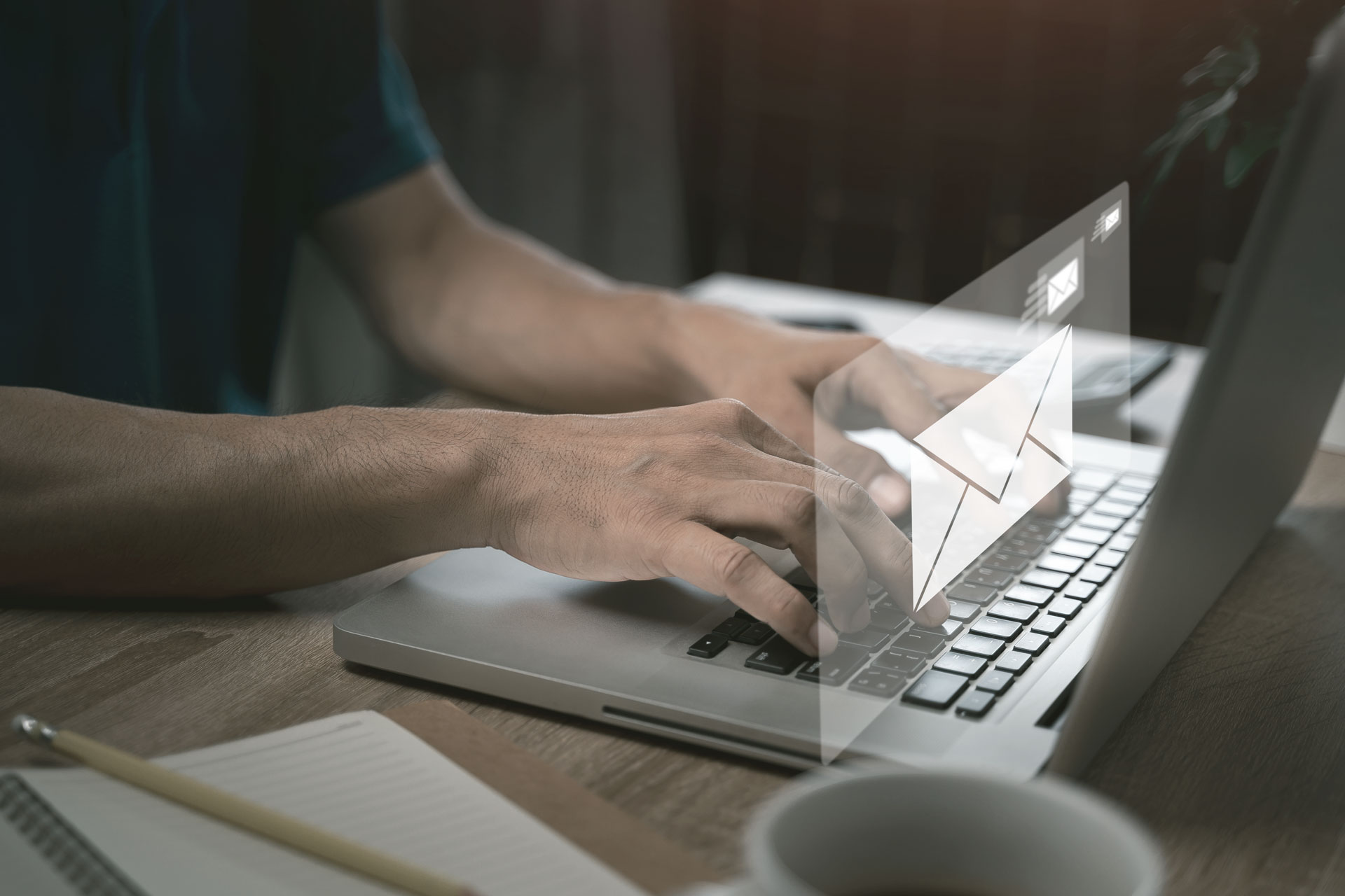 Mann schreibt eine Email am Laptop