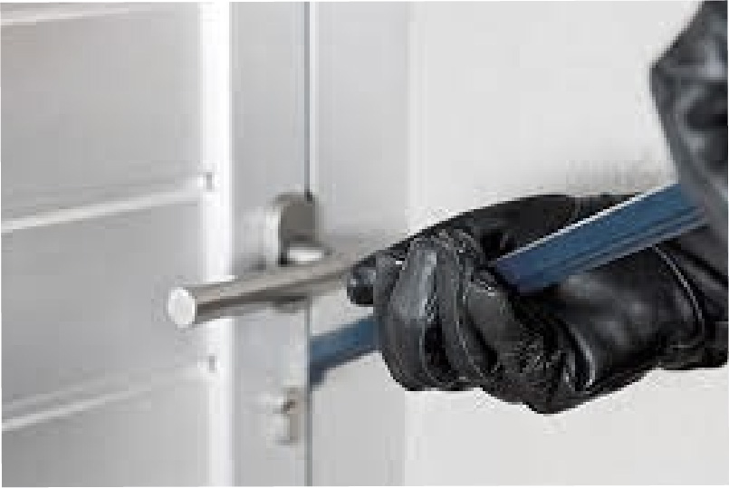 Einbrecher mit Einbruchswerkzeug in der Hand versucht eine Tür zu öffnen